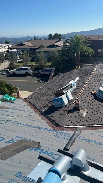 An image showing a close-up view of a damaged roof, with roofing materials and debris visible.